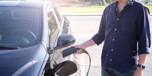 Mann ladet Elektroauto auf