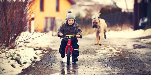 Kind auf dem Fahrrad in winterlicher Umgebung