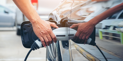 Person lädt Elektroauto auf