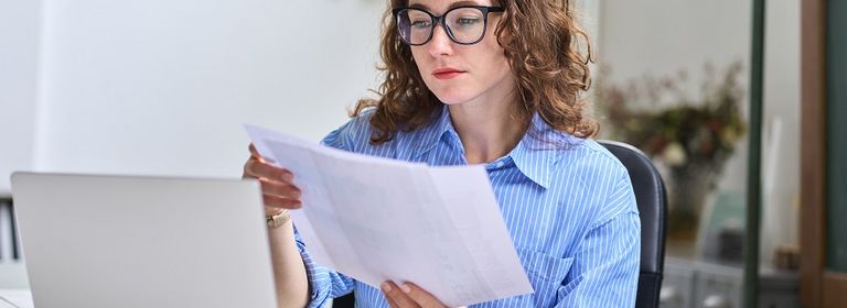 Frau sitzt am Laptop und liest über das Exekutionspaket